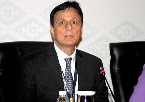 Asian man seated at a panel discussion